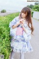 A young woman in a blue and white kimono holding a flower.