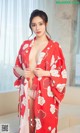 A woman in a red kimono posing for the camera.