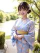 A woman in a blue kimono posing for a picture.