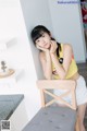 A woman sitting on a chair in a kitchen.