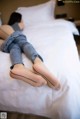 A woman laying on a bed with her legs crossed.