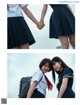 A couple of girls in school uniforms holding hands.