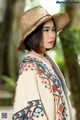 A woman wearing a straw hat and a colorful shawl.