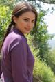 A woman in a purple dress posing for a picture.