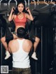 A man and a woman in a gym with weights.