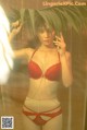 A woman in a red bra and panties posing for a picture.