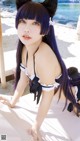 A woman with long black hair wearing a cat ears headband.