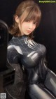 A woman in a black and silver spider suit posing for a picture.