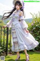 A woman in a white dress and purple shoes posing for a picture.