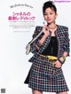 A woman in a colorful jacket and skirt posing for a magazine.